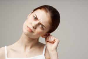 woman holding her ear health problems