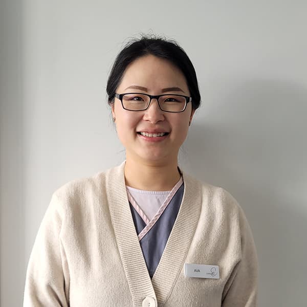 headshot of a female nurse wearing glasses with a name tag Ava