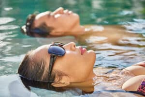 Couple swimming in pool of spa resort together