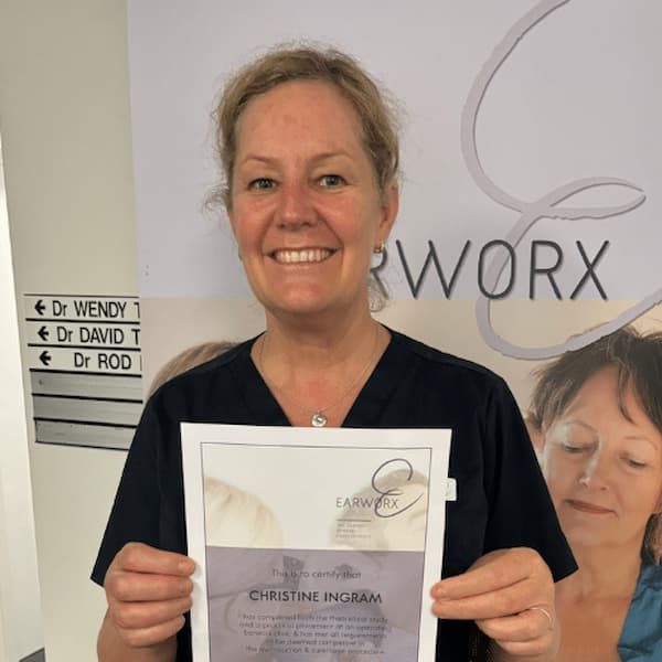 headshot of a nurse holding a certificate